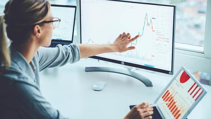 Businesswoman Studying Financial Market 718 x 404